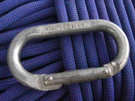 close up of blue rock climbing rope and used carabinerの写真素材
