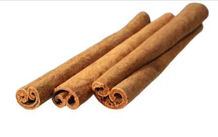three cinnamon sticks from an angle with a shallow depth of field isolated on whiteの写真素材