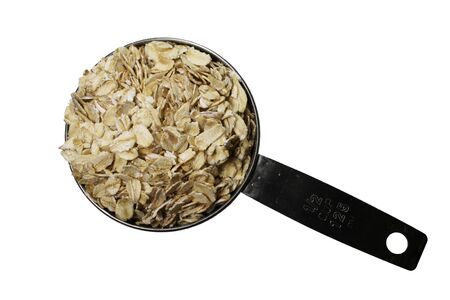 dry rolled oats or oatmeal in a metal half-cup scoop isolated on whiteの写真素材