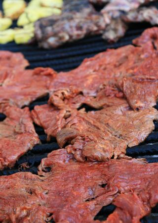 flank steak cooking on a barbecue grillの写真素材