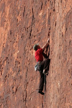 man in red rock lead climbing a red sandstone cliff at Red Rocks, Nevadaの写真素材