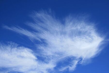 horizontal image of blue sky with wispy white  cirrus clouds