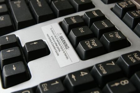close up of carpal tunnel warning on gray and black computer keyboard