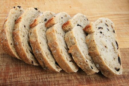 rosemary kalamata olive bread slices on wooden cutting board