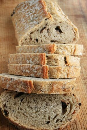 rosemary kalamata olive bread loaf and slices on wooden cutting board