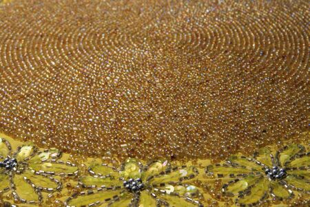 antique yellow beaded mat from an angle with a shallow depth of fieldの写真素材