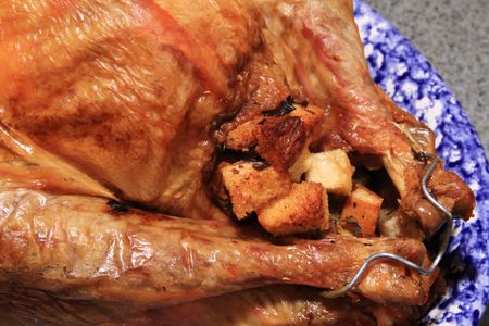 close up of baked turkey with stuffing on a blue and white platterの写真素材
