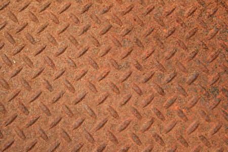 rusty textured steel panel with raised diamond patternの写真素材