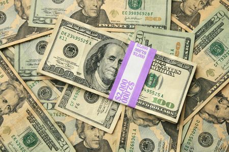 two thousand dollars in 100 bills on a background of twenty dollar US billsの写真素材