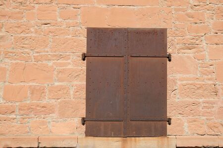 rusty metal doors in red sandstone wall