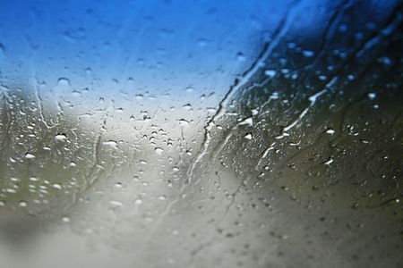 view through a wet car windshield with shallow depth of field and focus on the water dropsの写真素材
