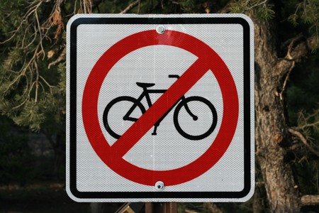 no bicycle sign with pine trees behind itの写真素材