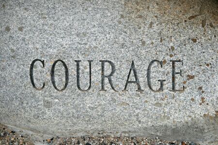 the word courage carved onto a granite cobble stoneの写真素材