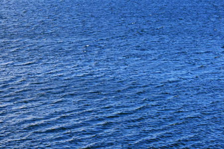 background detail of a blue lake with waves and a few whitecapsの写真素材