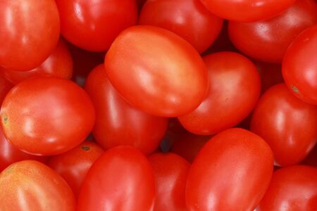 close up of many red cherry tomatoes making a backgroundの写真素材