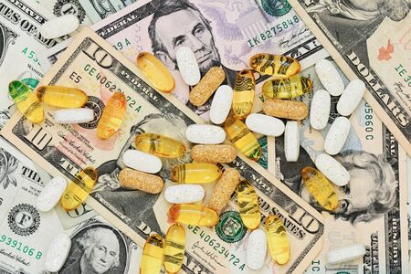 drug pills on a background of US paper moneyの写真素材