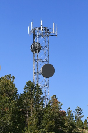 microwave and cell phone antenna tower on the top of a hillの写真素材