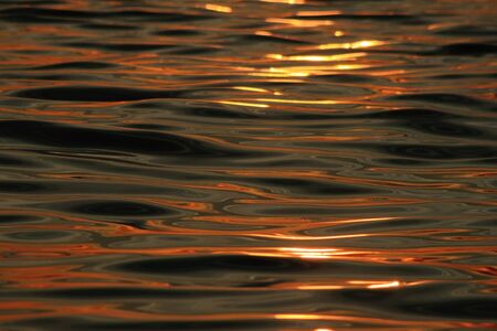 evening sunset reflection on rippling ocean waterの写真素材