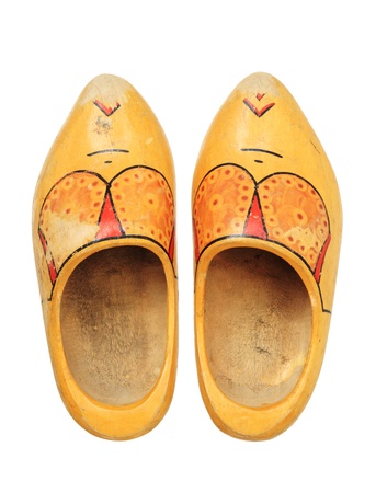 old worn used dutch wooden shoes on white background