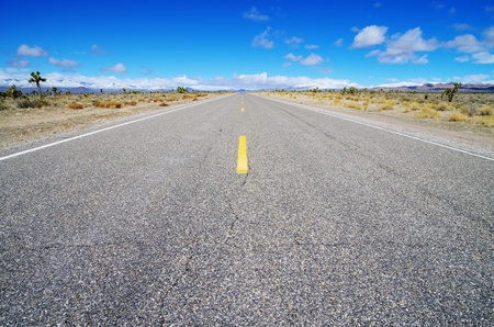 empty high desert road heading straight across Nevada