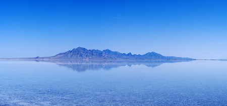 flooded Bonneville Salt Flats with distant mountains and blue sky reflectionの写真素材