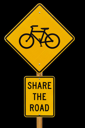 share the road with bicycles road sign isolated on black backgroundの写真素材
