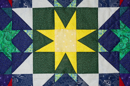 hand made quilt detail with colorful patterned clothの写真素材