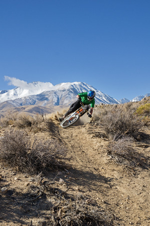 a mountain biker leans into a turn in the desert foothills with mountain in the background and copy spaceの写真素材