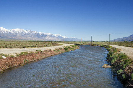 Los Angeles aqueduct in the Owens Valley with snowy Sierra Nevada mountainsの写真素材