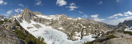 Picture Peak and partly frozen Hungry Packer Lake in July with a lot of snow in the Sierra Nevada Mountains of Californiaの写真素材