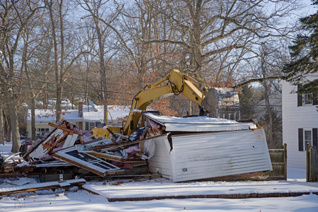 residential demolition with an excavator in the winterの写真素材