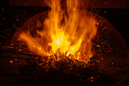 hot blacksmith forge with burning coals and sparksの写真素材