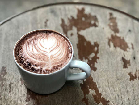 Cup of hot chocolate on wooden table, closeup. Space for text