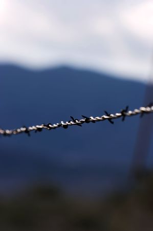 Barbed wire fence with Rocky Mountains in background.の写真素材