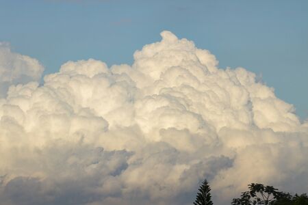 powerful and active white cumulonimbus cloud in a deep blue sky