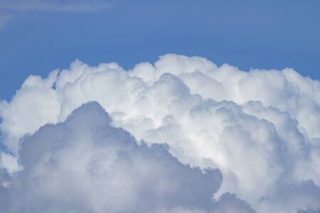 powerful and active white cumulonimbus cloud in a deep blue skyの写真素材