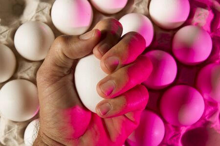 colorful hand holding eggs carton or box showing shape,light and shadow patterns