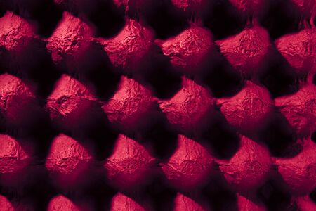 deep red empty eggs carton or box showing shape,light and shadow patterns