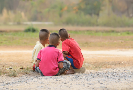cute kids seated on grass and relaxingの写真素材