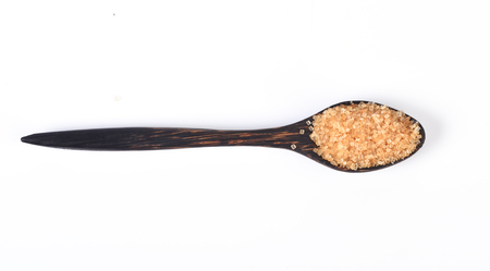 Brown sugar on wooden spoon isolated.の写真素材