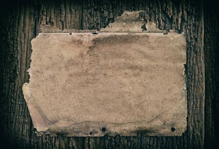 vintage grunge burnt paper at dark wooden backgroundの写真素材