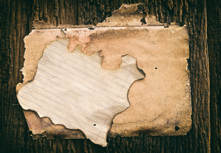 vintage grunge burnt paper at dark wooden backgroundの写真素材