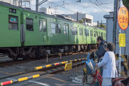 Kyoto, Japan-December 14,2015 : the old woman and man are waiting to cross the railroadのeditorial素材