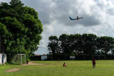 BADUNG,BALI/INDONESIA-APRIL 05 2019: Elementary student in Bali play football or soccer on the field near the airport with red jersey.のeditorial素材