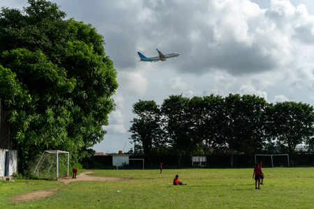 BADUNG,BALI/INDONESIA-APRIL 05 2019: Elementary student in Bali play football or soccer on the field near the airport with red jersey.のeditorial素材
