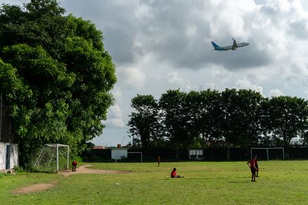 BADUNG,BALI/INDONESIA-APRIL 05 2019: Elementary student in Bali play football or soccer on the field near the airport with red jersey.のeditorial素材