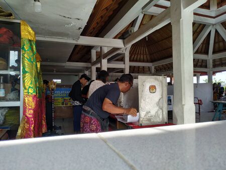 BALI/INDONESIA-APRIL 17 2019: Balinese people vote for the president and parliament 2019. They go to the polling stations using traditional Balinese clothesのeditorial素材