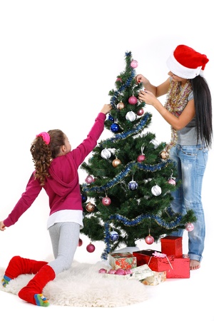 Mother and daughter near a christmas tree with gifts, isolated on a white backgroundの写真素材