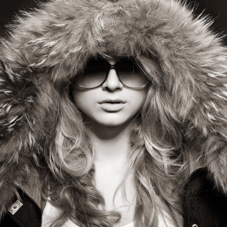A photo of sexual beautiful girl is in fashion style in a jacket with a fur hoodの写真素材