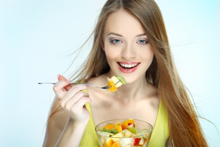 Portrait of a pretty young woman eating fruit saladの写真素材